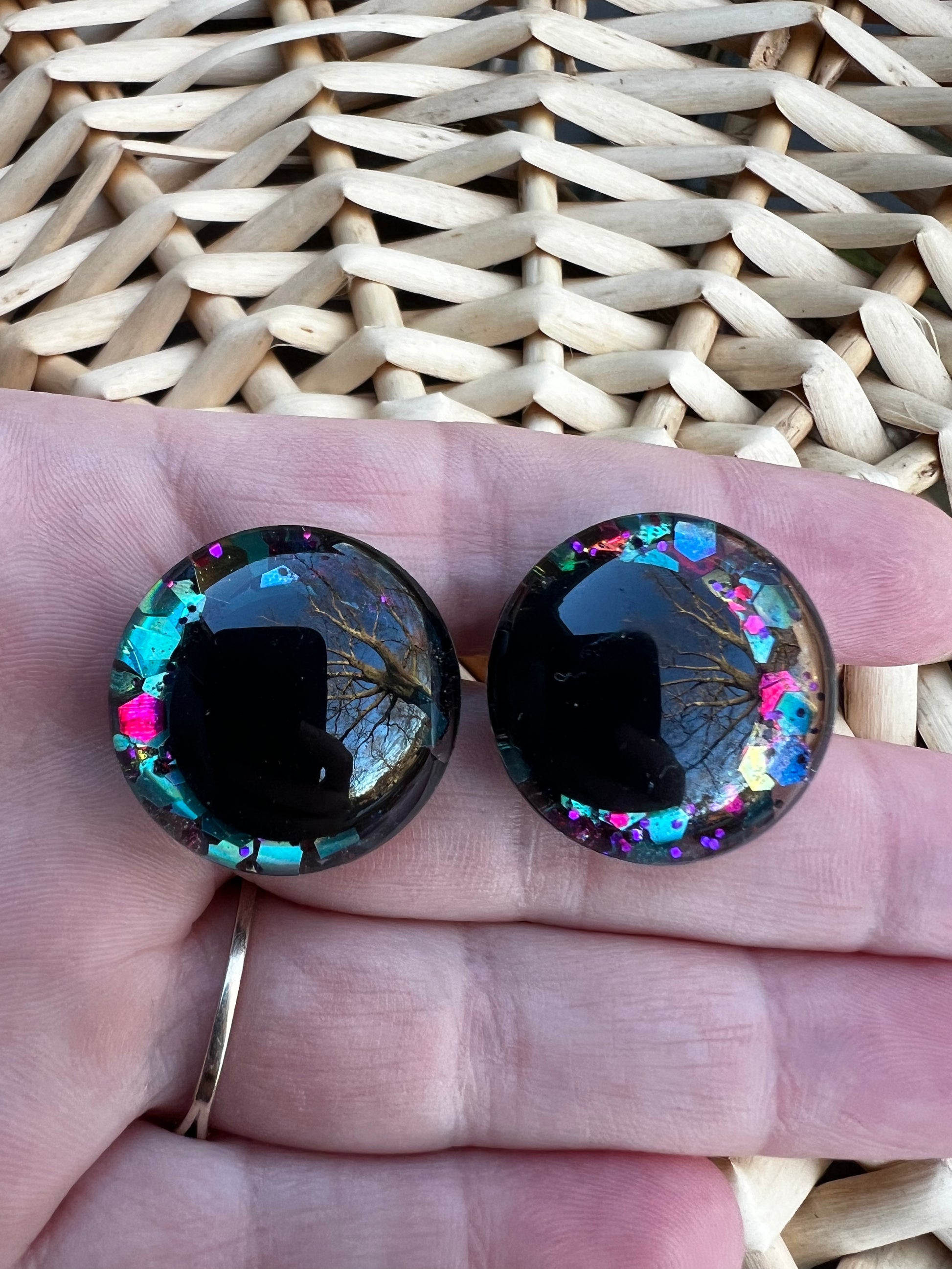 Hand painted safety eyes that feature large kawaii style black pupils with a vibrant shimmery jewel toned iris with purple, pink, and blue glitter throughout. Eyes are for crochet and knit amigurumi 