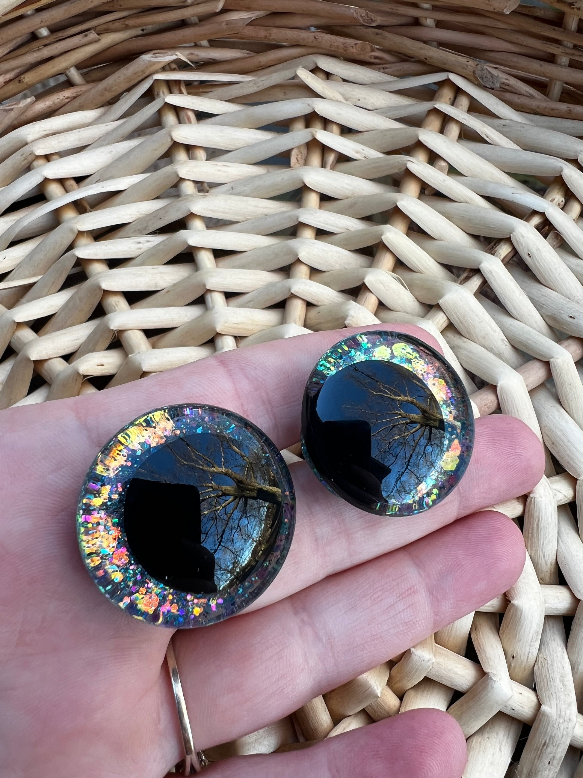 Hand painted safety eyes that feature large kawaii style black pupils and a vibrant orange, pink, and blue sparkly iridescent iris. Eyes are for crochet and knit amigurumi projects.