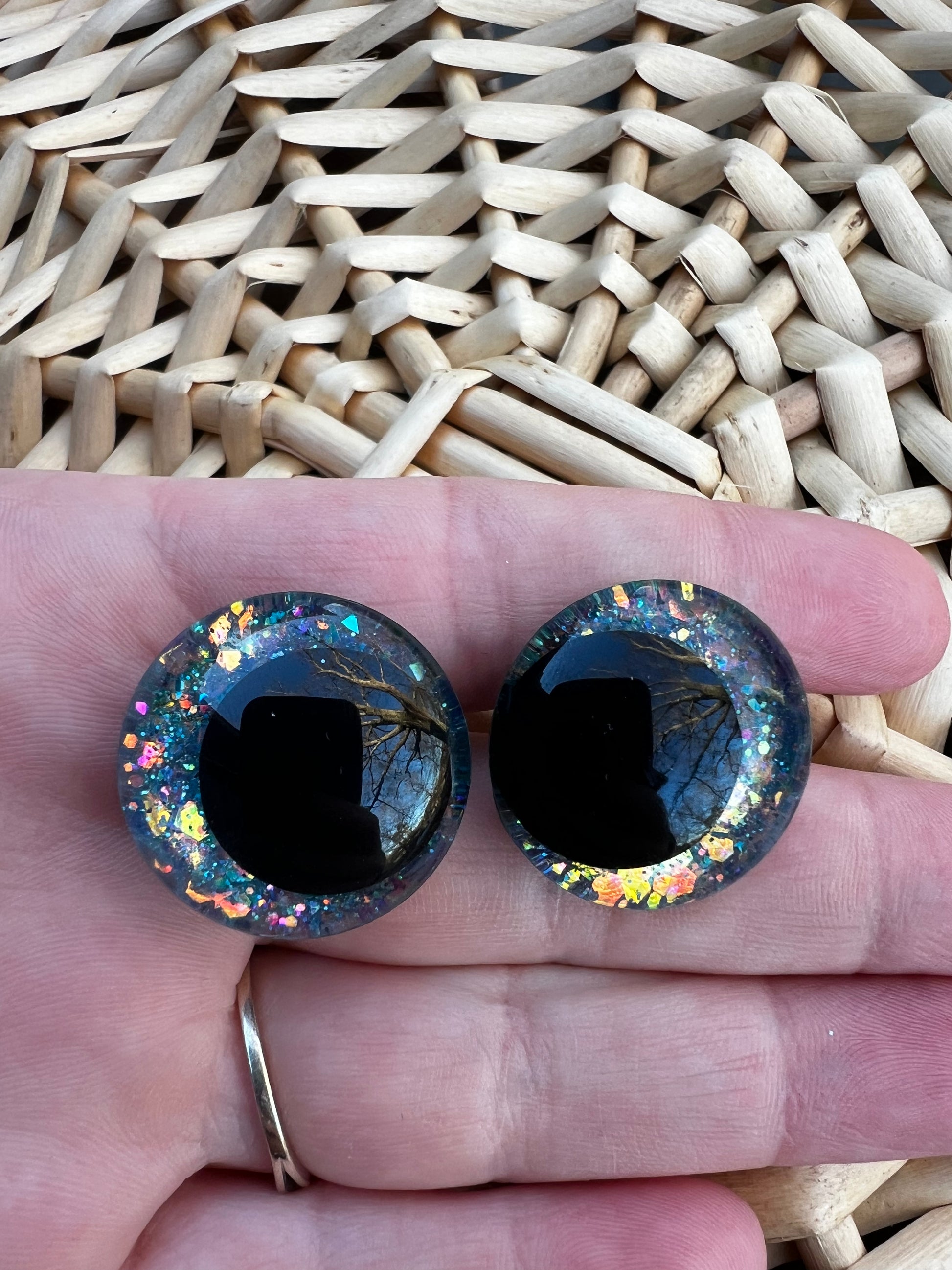 Hand painted safety eyes that feature large kawaii style black pupils and a vibrant orange, pink, and blue sparkly iridescent iris. Eyes are for crochet and knit amigurumi projects.