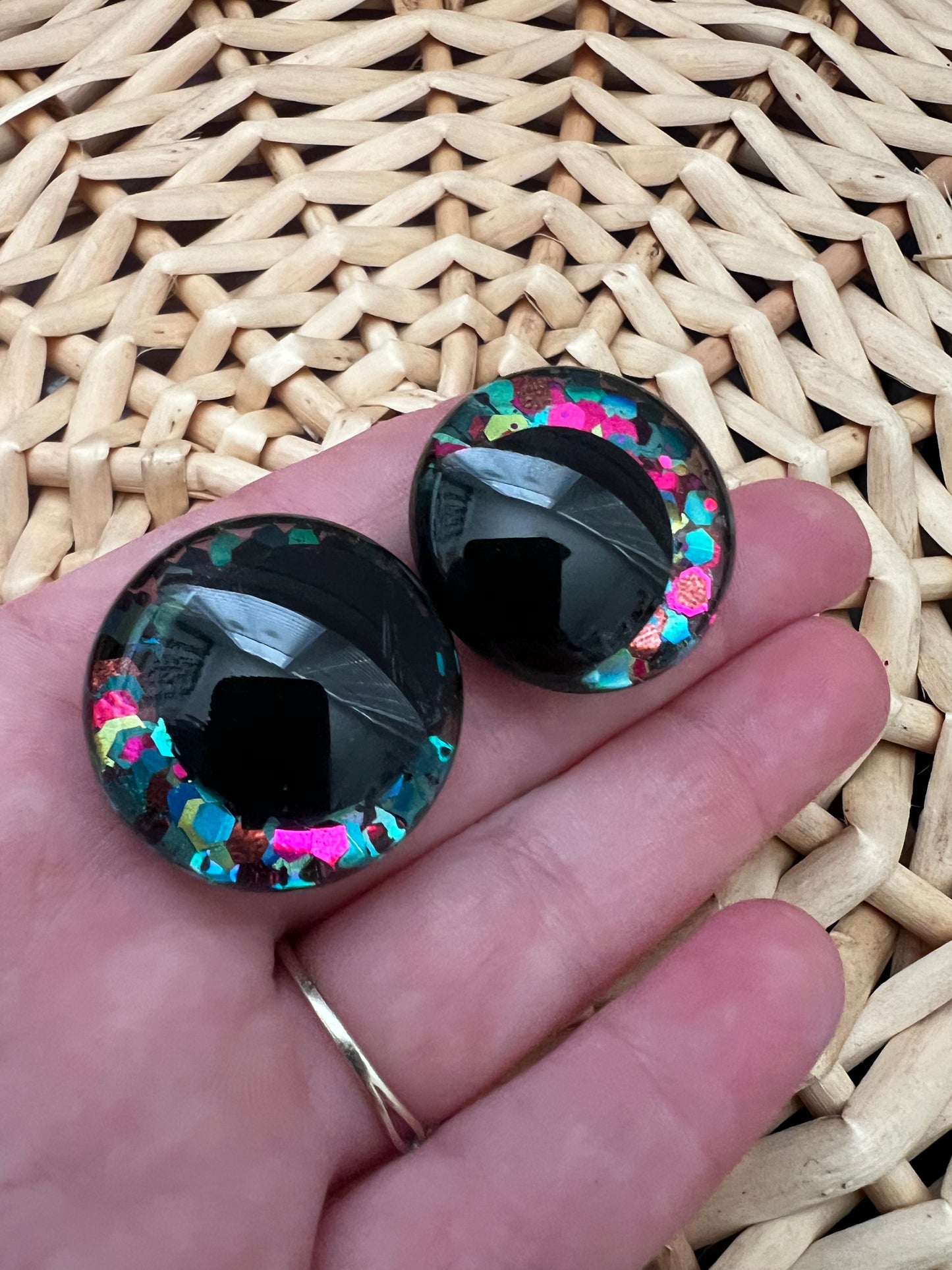 Hand painted safety eyes that feature large kawaii style black pupils with a vibrant shimmery jewel toned iris with purple, pink, and blue glitter throughout. Eyes are for crochet and knit amigurumi 