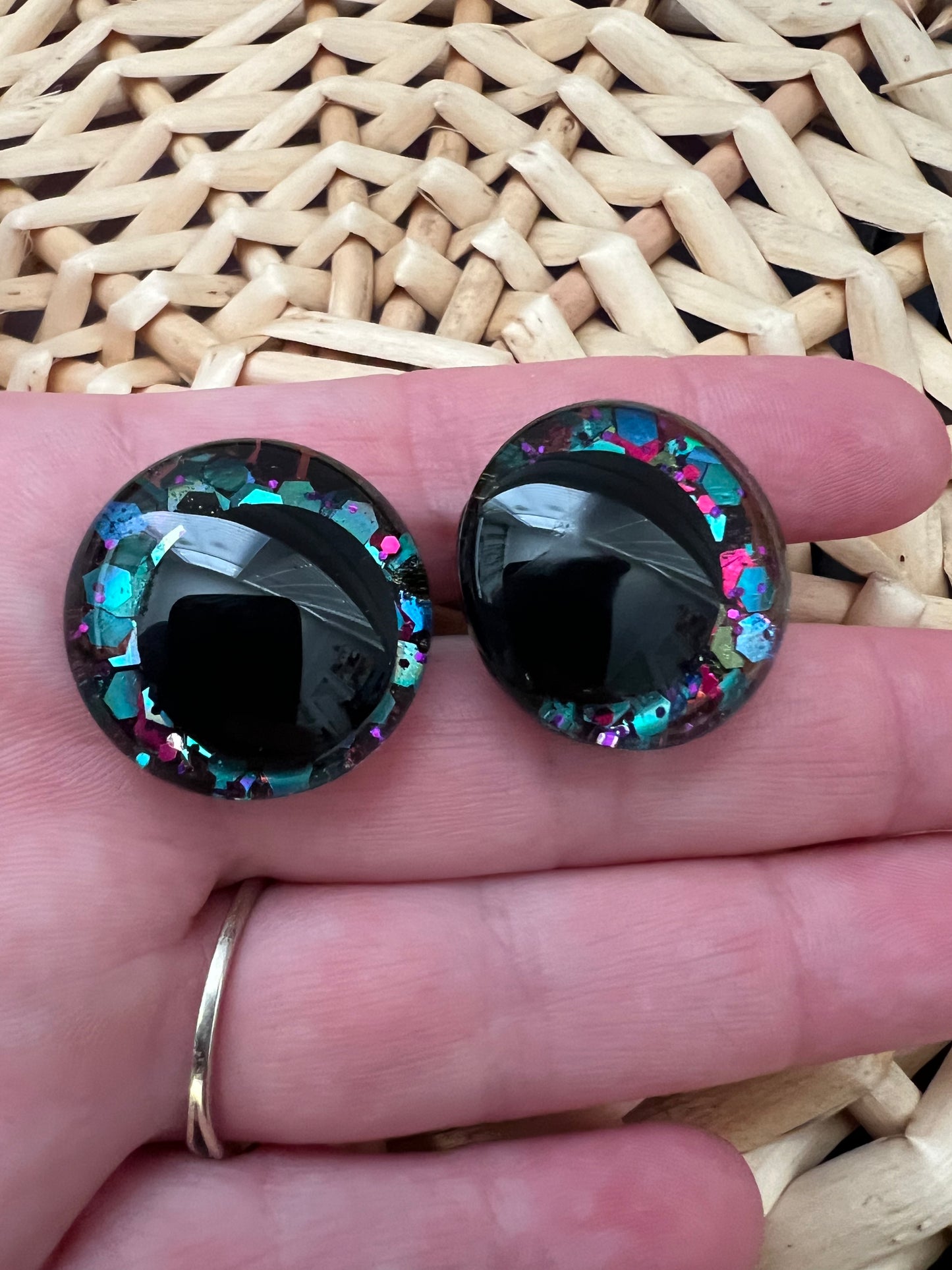 Hand painted safety eyes that feature large kawaii style black pupils with a vibrant shimmery jewel toned iris with purple, pink, and blue glitter throughout. Eyes are for crochet and knit amigurumi 