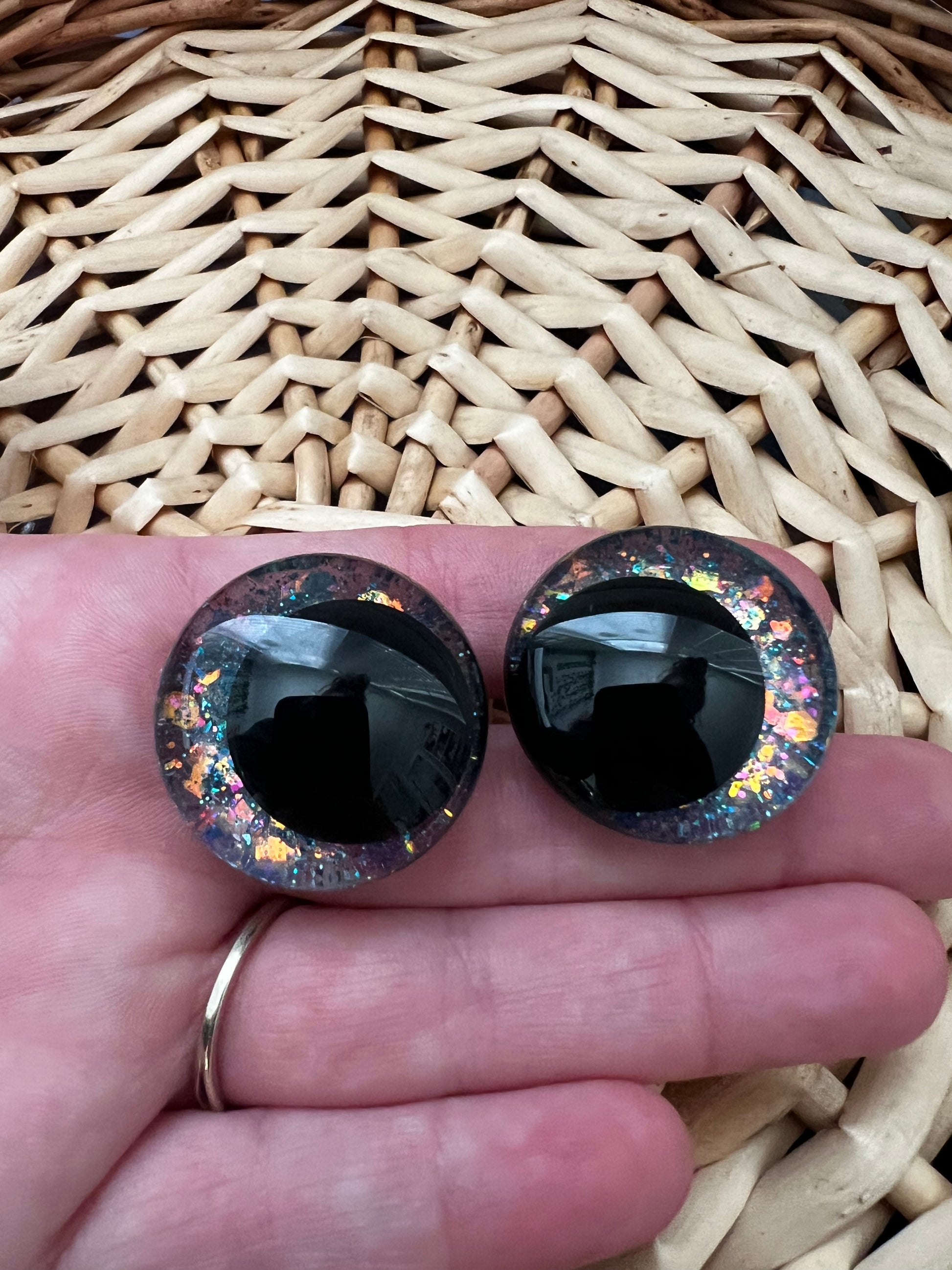 Hand painted safety eyes that feature large kawaii style black pupils and a vibrant orange, pink, and blue sparkly iridescent iris. Eyes are for crochet and knit amigurumi projects.