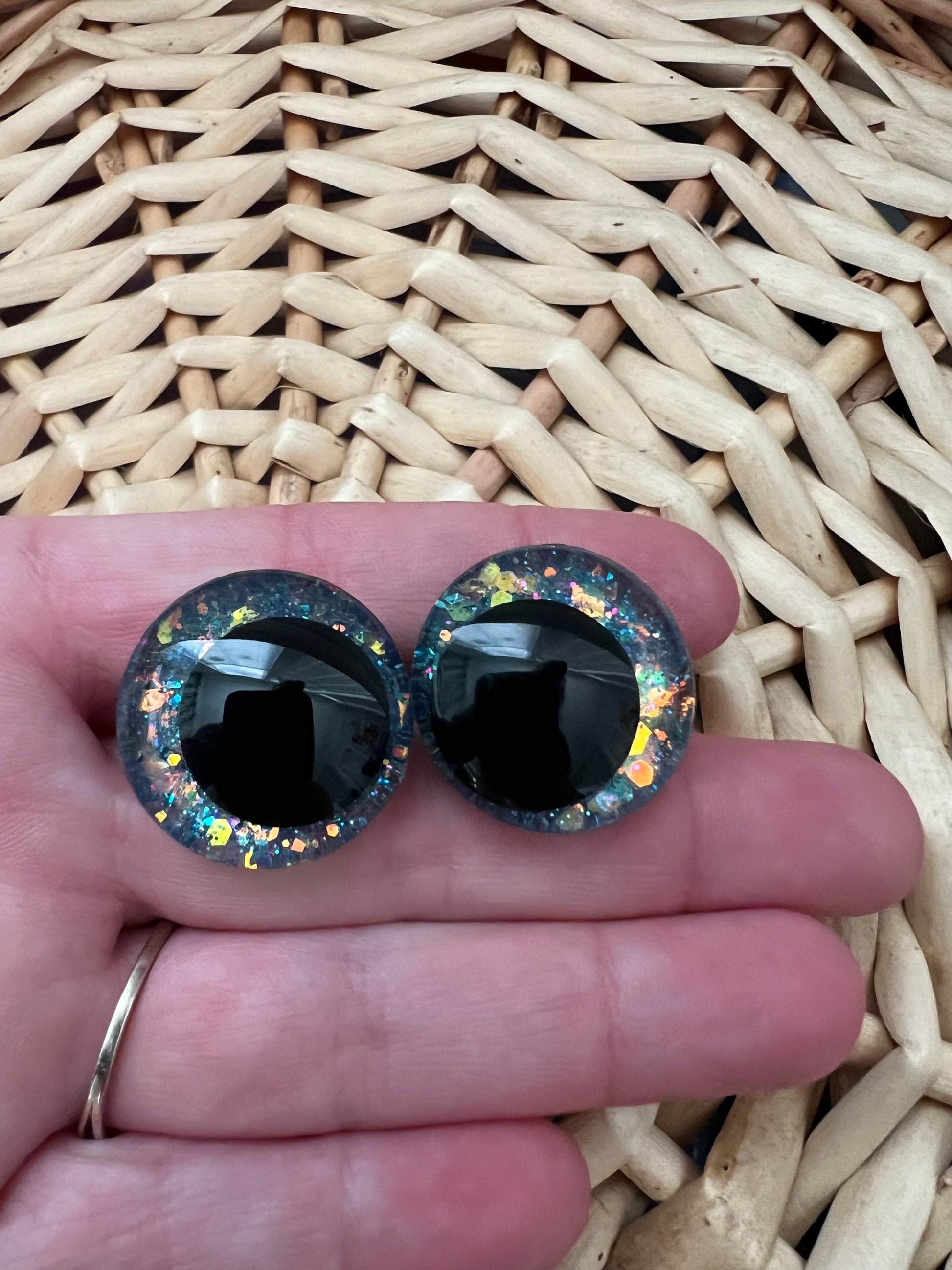 Hand painted safety eyes that feature large kawaii style black pupils and a vibrant orange, pink, and blue sparkly iridescent iris. Eyes are for crochet and knit amigurumi projects.