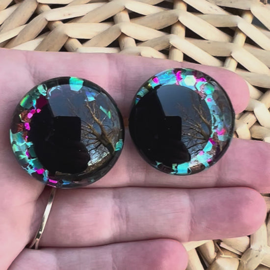 Hand painted safety eyes that feature large kawaii style black pupils with a vibrant shimmery jewel toned iris with purple, pink, and blue glitter throughout. Eyes are for crochet and knit amigurumi 
