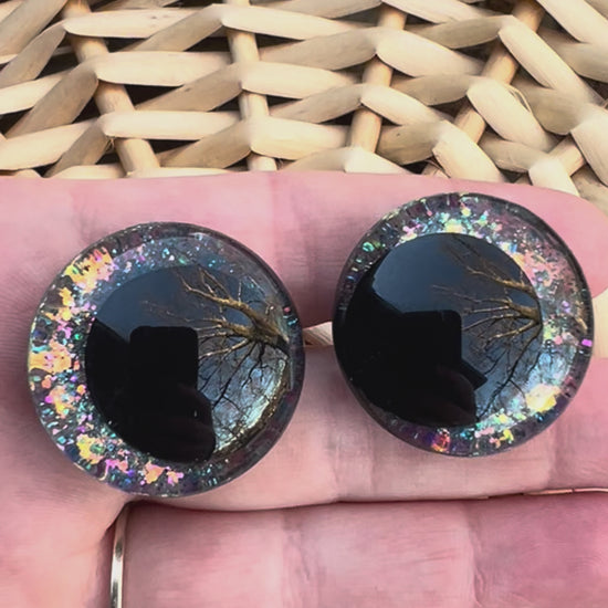 Hand painted safety eyes that feature large kawaii style black pupils and a vibrant orange, pink, and blue sparkly iridescent iris. Eyes are for crochet and knit amigurumi projects.